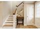 Elegant staircase featuring hardwood steps, white risers, and a wooden railing at 7613 W Stonegate Dr, Zionsville, IN 46077