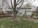 Back exterior showcasing sunroom, deck, large yard with swing set, and mature trees at 8160 Bold Forbes Ct, Indianapolis, IN 46217