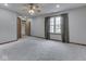 Spacious bedroom with neutral carpet, ceiling fan, and natural light from a large window at 8160 Bold Forbes Ct, Indianapolis, IN 46217