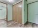 Hallway featuring a closet and doors in a home with light green walls and wood-look floors at 8160 Bold Forbes Ct, Indianapolis, IN 46217