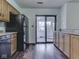 Well-lit kitchen featuring wood cabinets, black appliances, and a sliding glass door leading to a screened-in porch at 8160 Bold Forbes Ct, Indianapolis, IN 46217