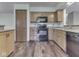 Well lit kitchen with wood cabinets, black appliances, and pantry at 8160 Bold Forbes Ct, Indianapolis, IN 46217