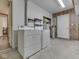 Well-lit laundry room with white washer and dryer units and access to other rooms at 8160 Bold Forbes Ct, Indianapolis, IN 46217
