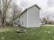 Rear exterior elevation showcasing sunroom, deck, spacious yard, and brick fire pit at 8160 Bold Forbes Ct, Indianapolis, IN 46217