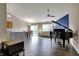 Open living room with high ceilings, hardwood floors, a piano, and a ceiling fan at 8312 Eagles Nest Dr, Avon, IN 46123