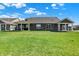 Wide shot of the backyard with ample green space and the rear of the house with covered patios at 8570 Hudson Way, Brownsburg, IN 46112