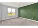 Bedroom featuring plush carpeting, a window, and a green accent wall at 8570 Hudson Way, Brownsburg, IN 46112