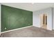 A stylish bedroom featuring a decorative green wall and neutral gray carpet at 8570 Hudson Way, Brownsburg, IN 46112