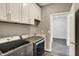 Modern laundry room featuring gray cabinets, a sink, and Maytag washer and dryer at 8570 Hudson Way, Brownsburg, IN 46112