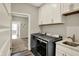 Bright laundry room with white cabinets, utility sink, and modern washer and dryer at 8570 Hudson Way, Brownsburg, IN 46112