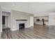 Living room featuring a fireplace, and wood flooring with a seamless flow into the kitchen at 8570 Hudson Way, Brownsburg, IN 46112