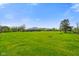 An expansive lawn stretches behind the home, accented by mature trees and clear blue skies at 8890 N Pennington Rd, Mooresville, IN 46158