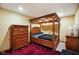 Basement bedroom featuring a stylish four-poster bed, matching dresser, and plush red rug at 8890 N Pennington Rd, Mooresville, IN 46158