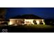Night view of a well-lit home with a brick facade, manicured landscaping, and lush green lawn at 8890 N Pennington Rd, Mooresville, IN 46158