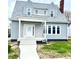 Charming two-story home featuring gray siding, white trim, and a welcoming front porch at 902 E 31St St, Anderson, IN 46016