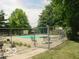 Community pool area surrounded by a metal fence and greenery at 928 Hoover Village Dr # 928D, Indianapolis, IN 46260