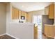 Modern kitchen featuring stainless steel appliances, light wood cabinetry, and a breakfast bar at 9763 Rolling Plain Dr, Noblesville, IN 46060