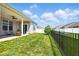 Fenced backyard featuring a covered patio, green lawn, and young tree at 9847 Bryce Blvd, Pendleton, IN 46064