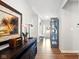 Inviting hallway with wood floors, console table and cabinet, leading to the front door at 9847 Bryce Blvd, Pendleton, IN 46064