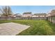 Spacious backyard with a large grassy area, a paved patio, and a wooden privacy fence at 10861 Tealpoint Dr, Indianapolis, IN 46229