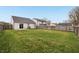 Large backyard with a well-maintained lawn and a wood privacy fence at 10861 Tealpoint Dr, Indianapolis, IN 46229