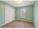 Inviting bedroom with refreshing green walls, soft carpeting, a bright window, and ample closet space at 10861 Tealpoint Dr, Indianapolis, IN 46229