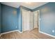 Stylish bedroom featuring blue walls, light wood flooring, and large closets, offering a comfortable and organized space at 10861 Tealpoint Dr, Indianapolis, IN 46229