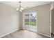 Inviting dining area with sliding glass doors leading to a fenced backyard with grass and a stone patio at 10861 Tealpoint Dr, Indianapolis, IN 46229