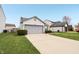 Well-maintained home with a spacious driveway, green lawn, and attached two-car garage at 10861 Tealpoint Dr, Indianapolis, IN 46229