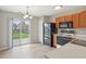 Cozy kitchen featuring stainless steel appliances, wood cabinets, and sliding glass doors to the backyard at 10861 Tealpoint Dr, Indianapolis, IN 46229