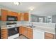 A cozy kitchen with wooden cabinets, white countertops and modern appliances offering a blend of style and functionality at 10861 Tealpoint Dr, Indianapolis, IN 46229