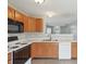 Well-lit kitchen featuring matching wooden cabinets, durable white countertops, and sleek appliances with modern gray walls at 10861 Tealpoint Dr, Indianapolis, IN 46229