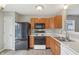 Functional kitchen with wood cabinets, black appliances, and white countertops at 10861 Tealpoint Dr, Indianapolis, IN 46229
