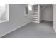 A finished basement featuring painted walls, concrete flooring, and a stairway to the upper level at 1125 N Colorado Ave, Indianapolis, IN 46201