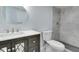 Bathroom with a gray vanity, updated fixtures, a round mirror, and tiled shower at 1125 N Colorado Ave, Indianapolis, IN 46201