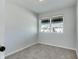 A simple bedroom with soft carpet, white walls, and a bright window offering ample light and outdoor views at 1125 N Colorado Ave, Indianapolis, IN 46201