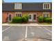 Two-story townhouse with brick exterior, neutral trim, black roof, and parking at 1131 Canterbury S Sq, Indianapolis, IN 46260