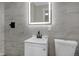 Modern bathroom with a lighted mirror, sleek vanity, and gray, stone-look tile at 11423 Mutz Cir, Indianapolis, IN 46229