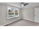 Bright bedroom featuring a ceiling fan, plush carpet, and a view of the backyard deck at 11423 Mutz Cir, Indianapolis, IN 46229
