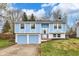 Split-level home boasts a colorful facade, attached two-car garage, and a welcoming entryway at 11423 Mutz Cir, Indianapolis, IN 46229