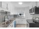 Modern kitchen features white cabinets, granite countertops, stainless steel appliances and mosaic tile backsplash at 11423 Mutz Cir, Indianapolis, IN 46229