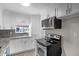 Well-lit kitchen with white cabinets, granite countertops, and modern appliances for a clean, updated look at 11423 Mutz Cir, Indianapolis, IN 46229