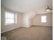 Well-lit finished attic featuring neutral paint, ceiling fan, and large windows at 11525 Capistrano Cir, Indianapolis, IN 46236