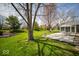 Expansive backyard with lush lawn, mature trees, and outdoor patio with dining set at 11525 Capistrano Cir, Indianapolis, IN 46236