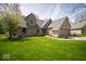 Charming brick home with an attached garage, lush green lawn, and mature trees on a sunny day at 11525 Capistrano Cir, Indianapolis, IN 46236
