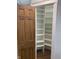 Spacious pantry with a beautiful wooden door, and open shelving for optimal organization and storage at 11525 Capistrano Cir, Indianapolis, IN 46236