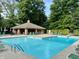 Community pool with cabana and lounge chairs surrounded by greenery at 11525 Capistrano Cir, Indianapolis, IN 46236