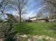 Expansive backyard featuring a well-manicured lawn, mature trees, and partial view of the home's exterior at 1235 Cottonwood Ct, Carmel, IN 46033