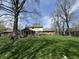 Spacious backyard showcasing a screened-in porch, lush lawn, and mature trees, perfect for outdoor enjoyment at 1235 Cottonwood Ct, Carmel, IN 46033