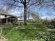 Lush backyard with mature trees, healthy green grass, and a screened-in porch attached to the home at 1235 Cottonwood Ct, Carmel, IN 46033